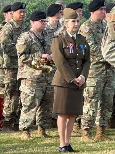 Mardi 4 juin 2024. Colleville-sur-Mer  (14), première cérémonie en Normandie, hommage à la 1ère division d’infanterie, Nathalie chante « La Marseillaise » accompagnée de la musique américaine, devant la colonne de la 1ère division.